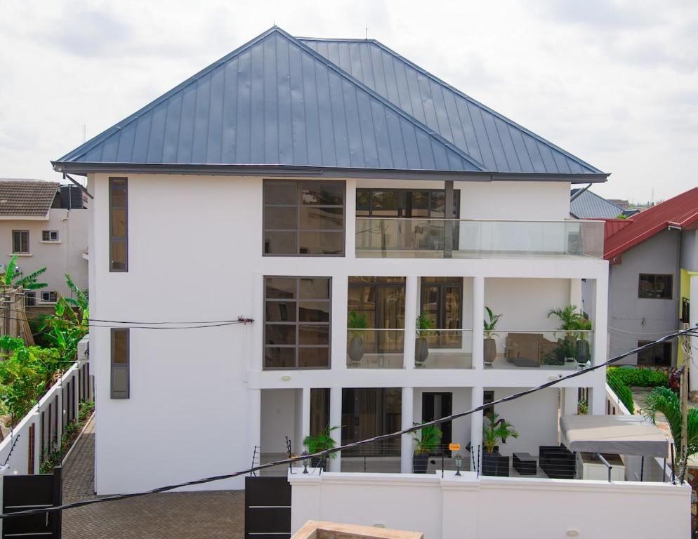 a white house with a black roof at Golden Hayat Suites in East Legon