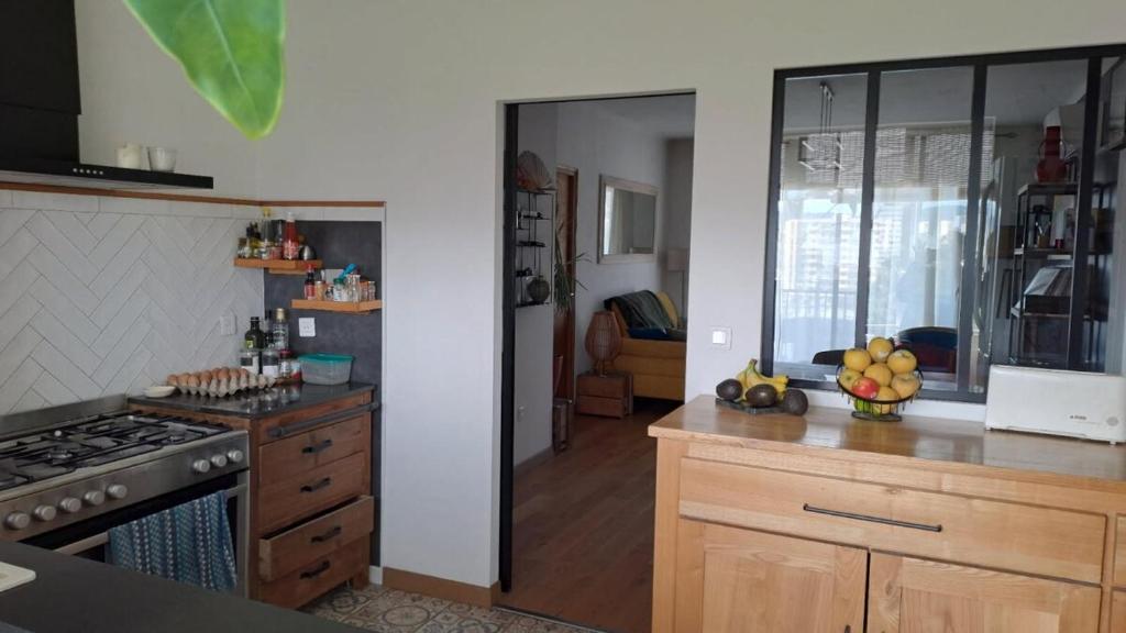 une cuisine avec une cuisinière et un comptoir dans l'établissement Charmant cosy T3, à Ajaccio