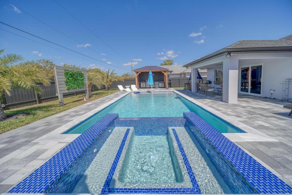 una piscina in un cortile con una casa di Campos Family Resort - Heated Pool a Cape Coral