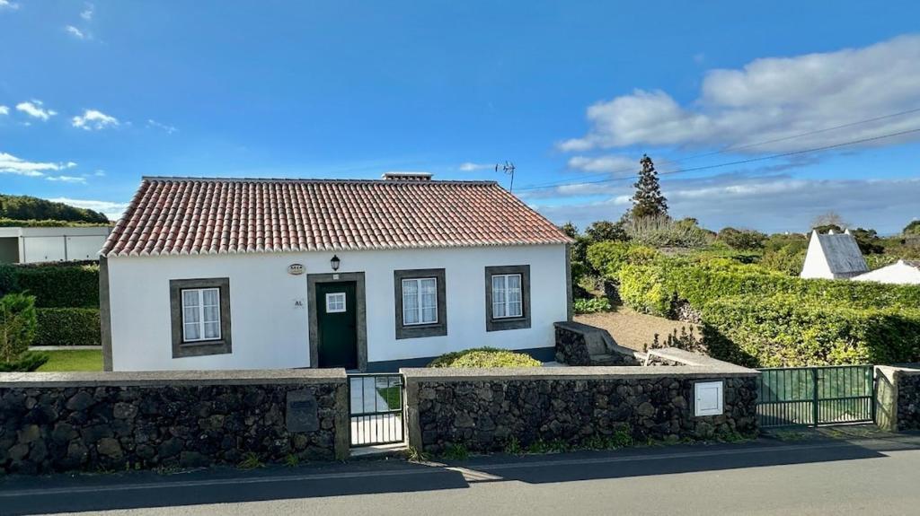 a small white house with a red roof at Retiro dos Biscoitos in Biscoitos