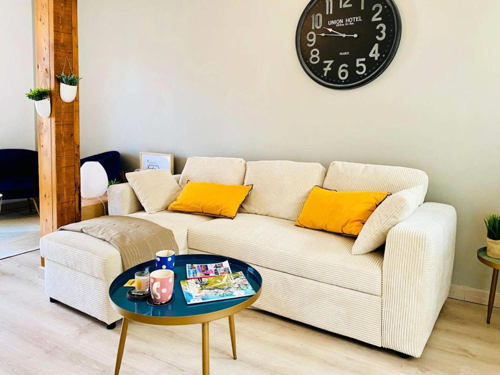 a living room with a couch and a clock on the wall at Résidence B20-perros Guirec - Maison avec terrasse près du port de Perros-Guirec MAE-3764 in Perros-Guirec