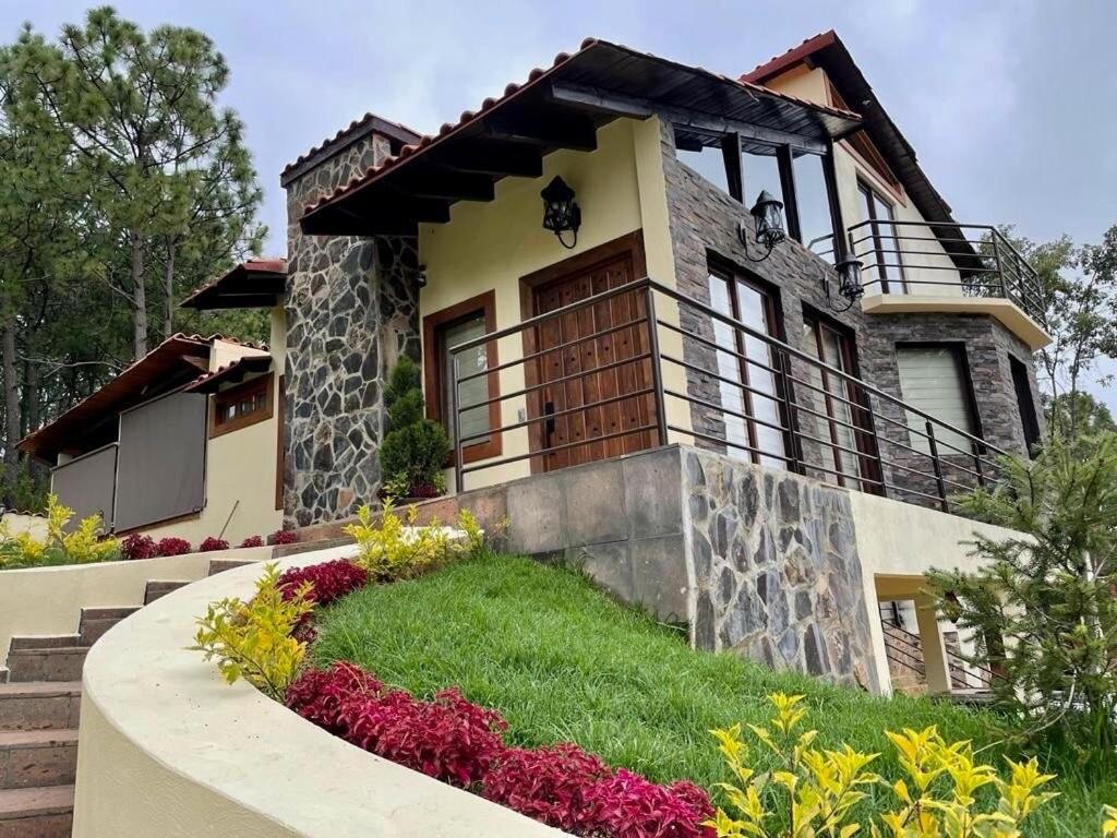 a house with some flowers in front of it at Cabaña de lujo en el Bosque in Mazamitla