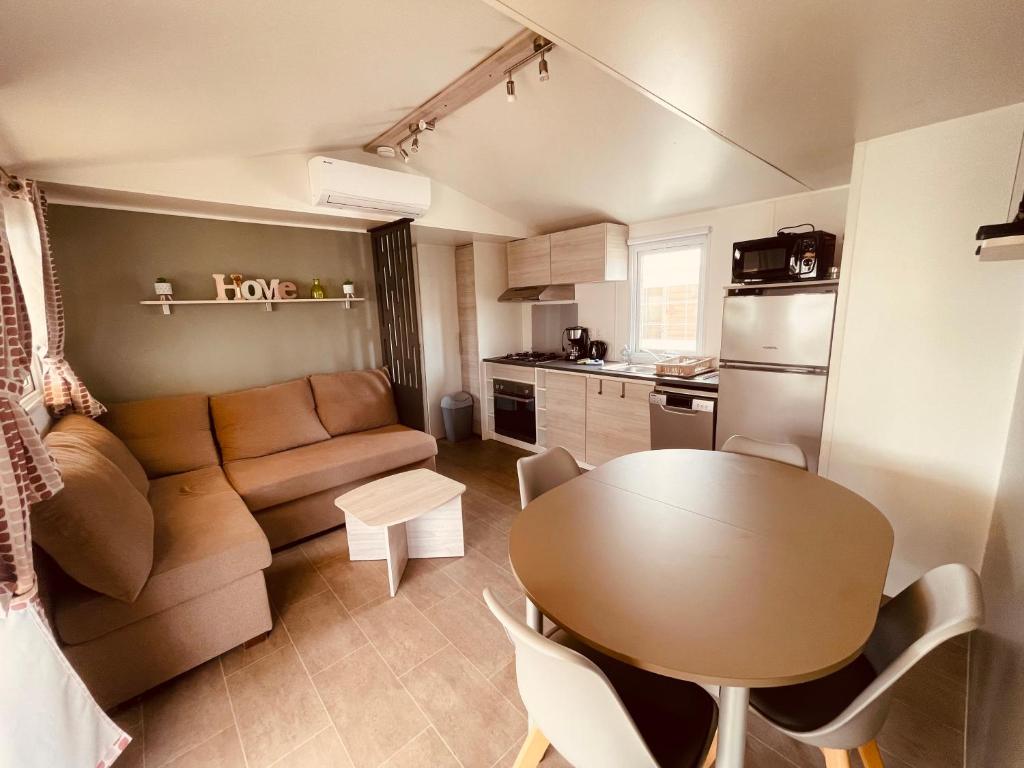 a small living room with a table and a couch at Mobil Home Bouginvilliers 3 in Valras-Plage