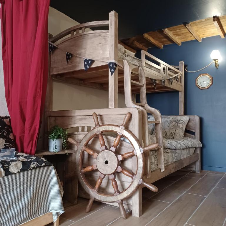 - une chambre avec une roue de bateau pirate à côté d'un lit superposé dans l'établissement Le trésor des Caraïbes, à Bussy-Saint-Georges