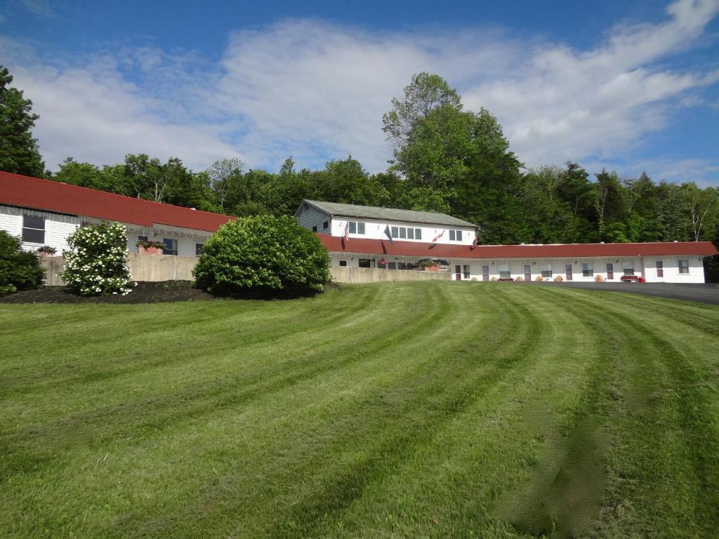ein großes Grasfeld vor einem Gebäude in der Unterkunft Mount Blue Motel in Farmington