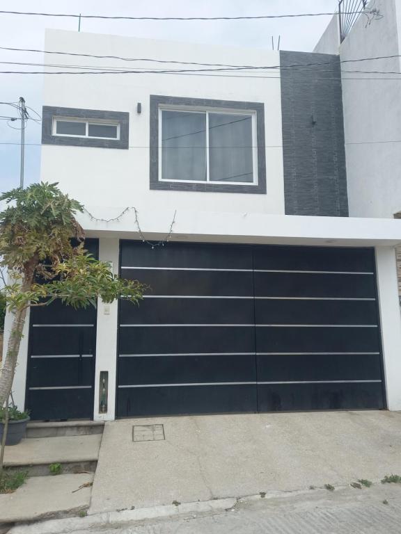 a garage with a black garage door on a house at La casa de wendy in Tuxtla Gutiérrez
