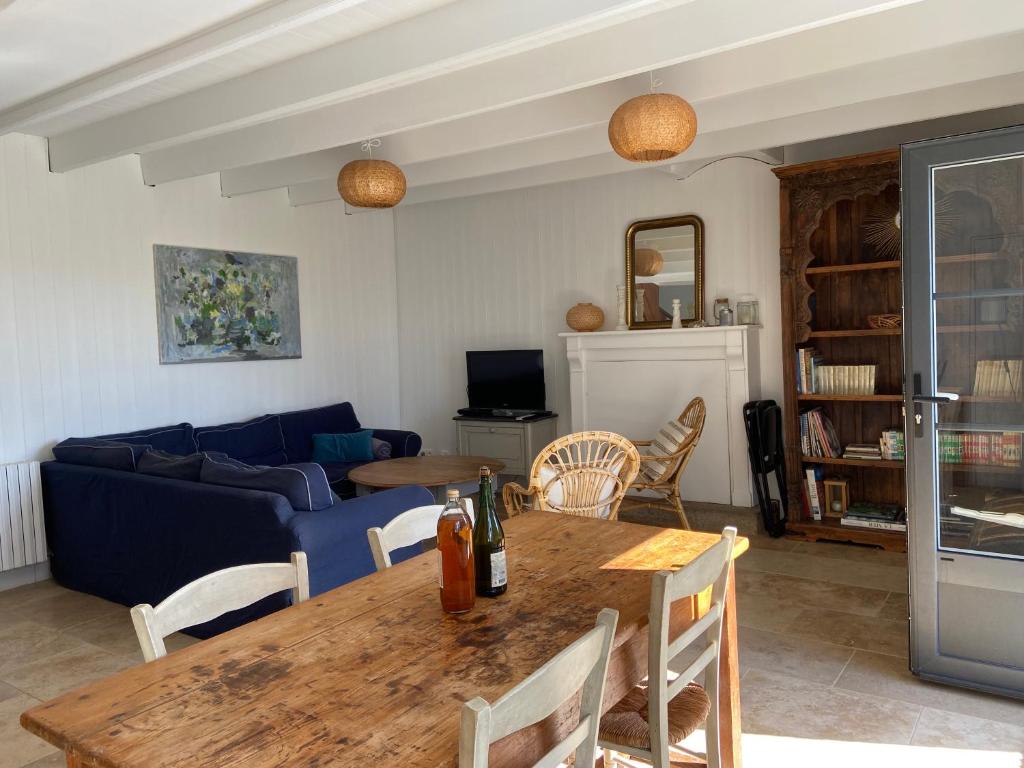 プルバスラネックにあるLe Gîte de Ker Ehden classé 3 étoilesのテーブルと青いソファのあるリビングルーム