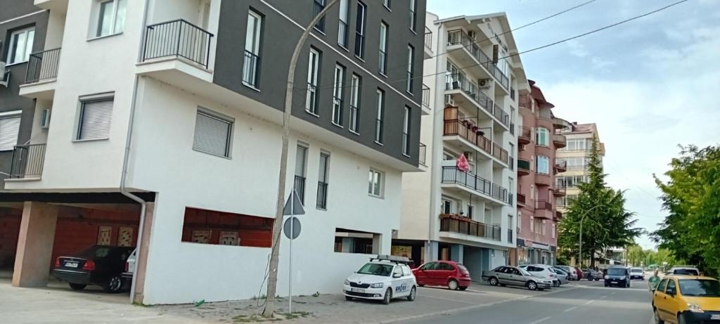 a street with cars parked in front of a building at Apartments Stela Rosa Ohrid in Ohrid
