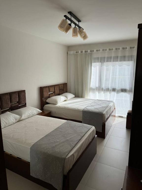 a bedroom with two beds and a window at Marassi luxury chalet in El Alamein