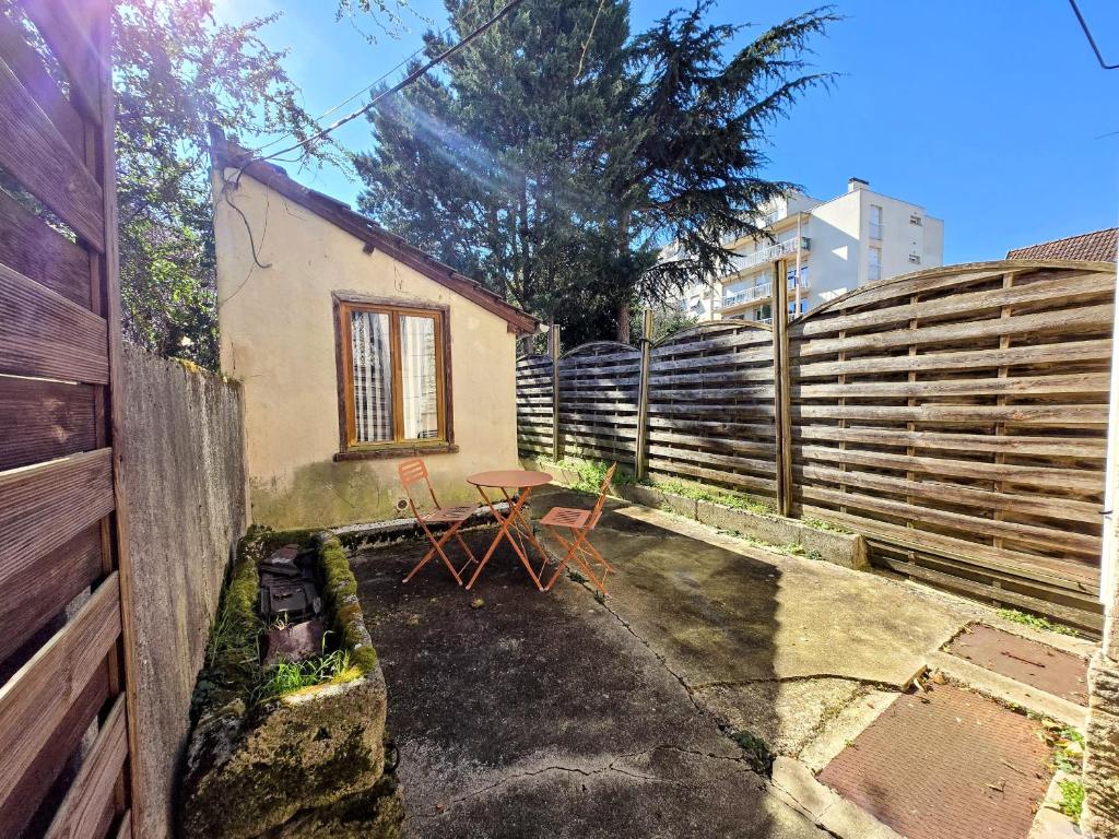a patio with a table and a fence at Le Saint Georges - Bail Partner in Auxerre