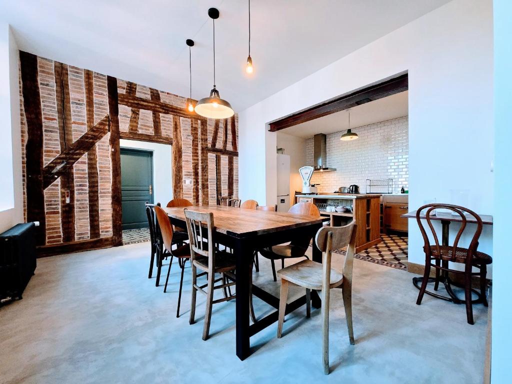 une salle à manger avec une table et des chaises en bois dans l'établissement La Marine - Sejour a Auxerre, à Auxerre