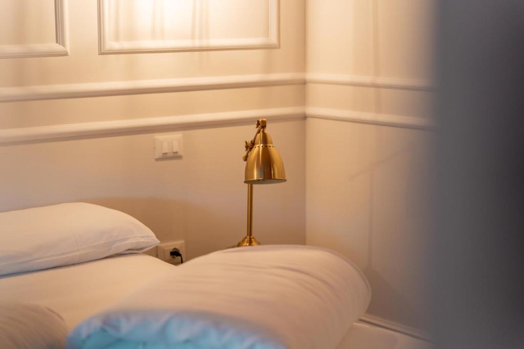 a room with a bed and a lamp next to it at Locanda Gaudemus Boutique Hotel in Sistiana
