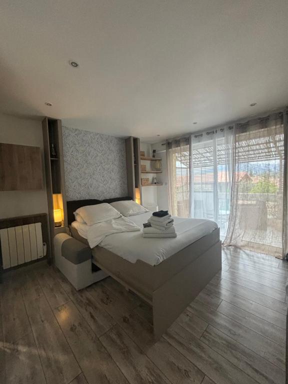 una camera da letto con un letto grande e una grande finestra di La Salamandre de l Olivier - le Palmier ad Aubignosc