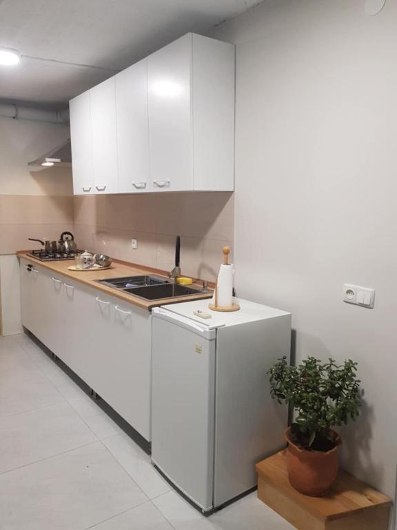 a kitchen with white cabinets and a counter top at Tkhibuli guest house in Tqibuli