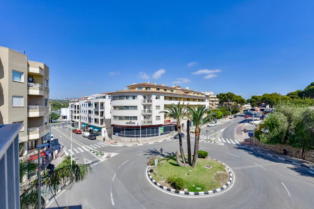 an empty street with a building and a palm tree at Flat 58 - City Center Moraira in Moraira