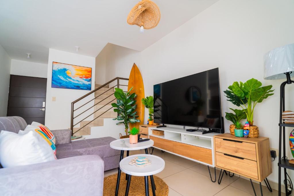 a living room with a couch and a tv and a surfboard at Casa Surf in Zaragoza
