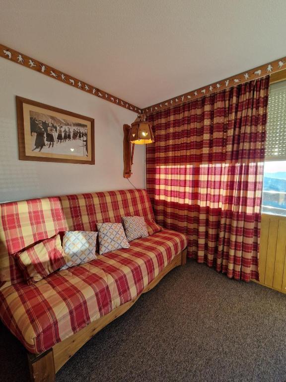 - un salon avec un canapé et une fenêtre dans l'établissement Montagne Studio Prapoutel Station, à Les Adrets