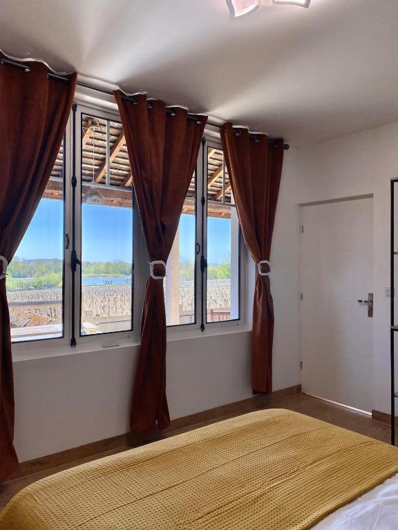 une chambre avec un lit et deux fenêtres dans l'établissement L'Espérance vue sur la vigne et la Loire, à Pouilly-sur-Loire