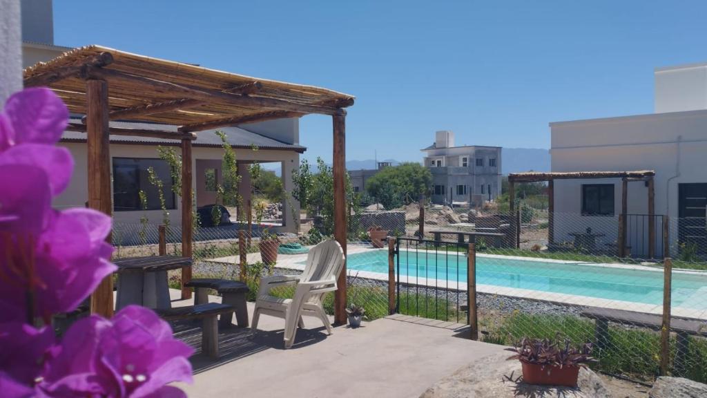 a patio with a table and chairs next to a pool at Las Casitas CAFAYATE in Cafayate