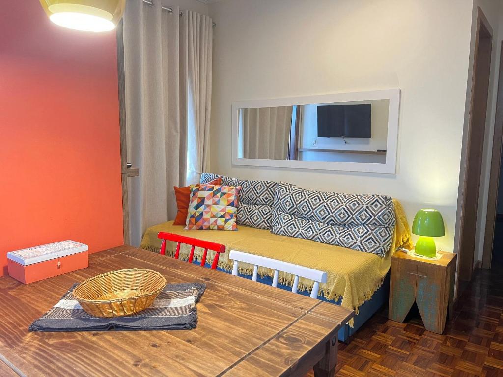 a living room with a couch and a table at Apto com sacada e vista vale dos vinhedos in Bento Gonçalves