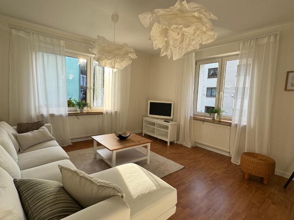 salon z białą kanapą i telewizorem w obiekcie Apartament w kamienicy Gdynia w mieście Gdynia