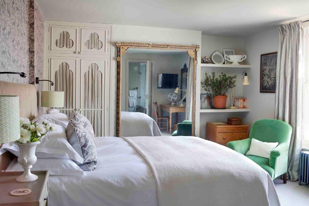 a bedroom with a white bed and a green chair at The George In Rye in Rye