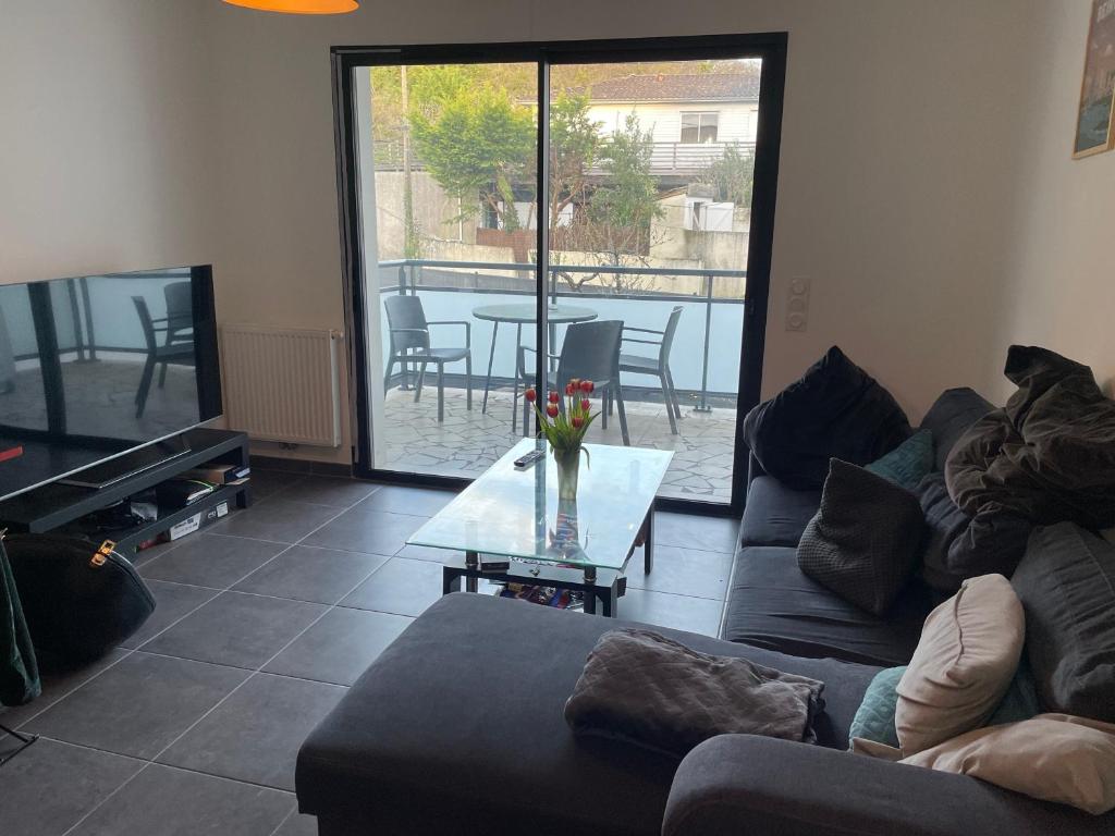 un salon avec un canapé et une table en verre dans l'établissement Villa Foch, à Cenon