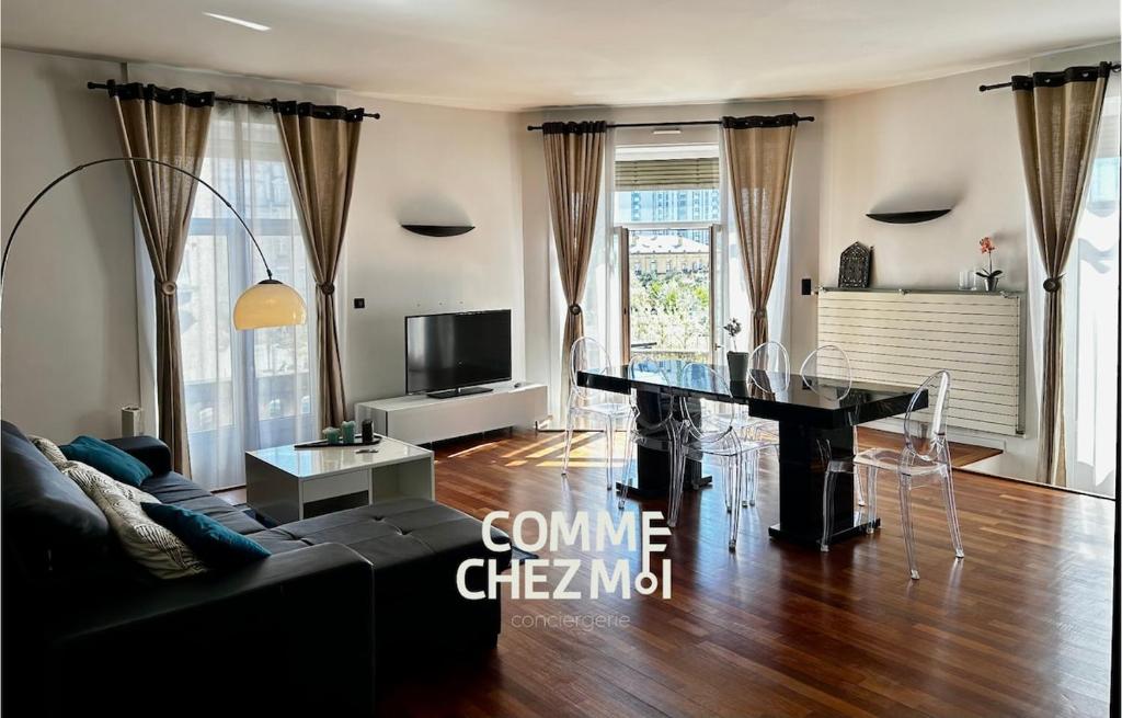 un salon avec une table et un canapé dans l'établissement Le Balcon de l'Excelsior avec parking, à Nancy