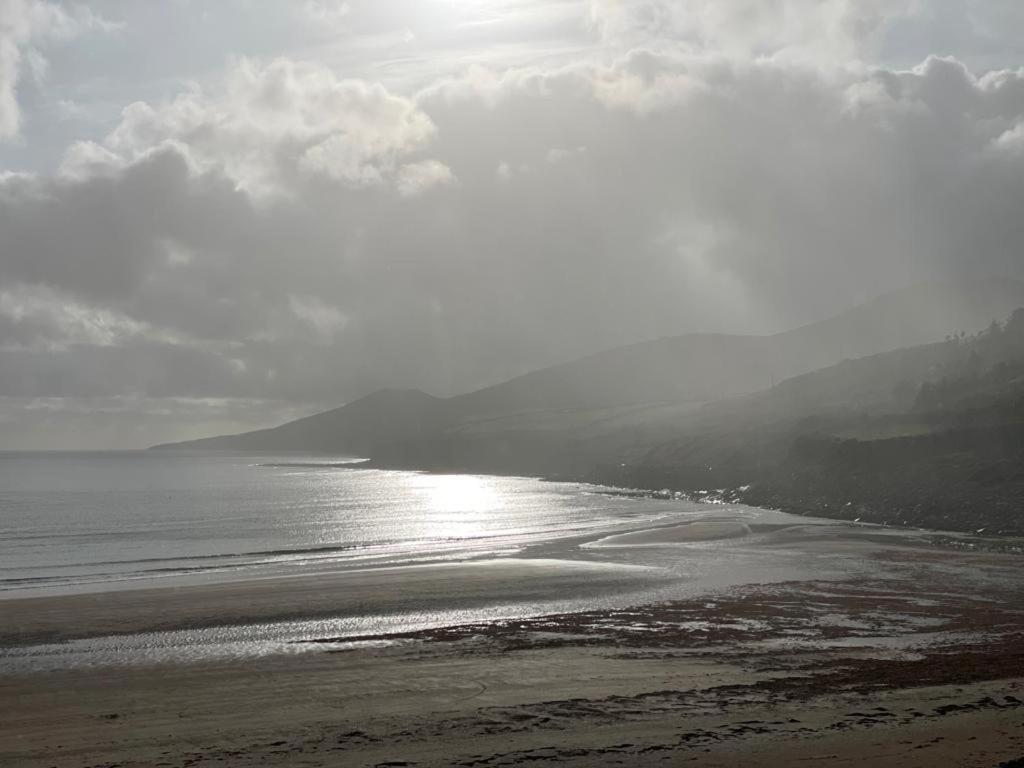 a beach with the sun reflecting on the water at Beach House Inch in Inch