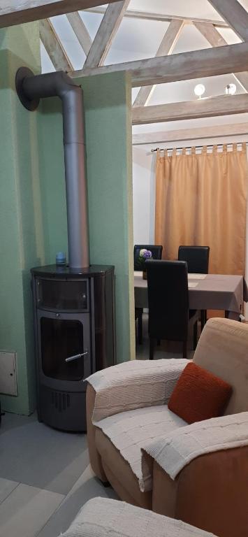 een woonkamer met een open haard, een bank en een tafel bij Zlatna Guest House in Kotor