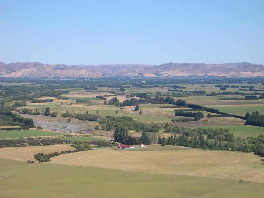 an aerial view of a field with mountains in the background at Pahau Downs in Culverden