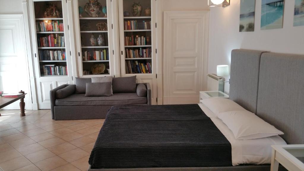 ein Wohnzimmer mit einem Bett und einer Couch in der Unterkunft Centro Storico Home in Catania
