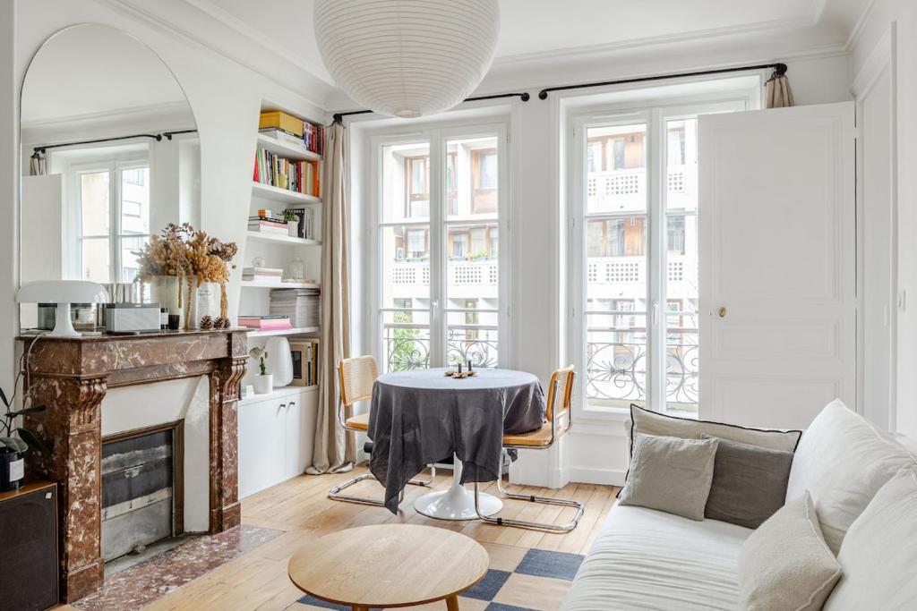 un salon avec une table et une cheminée dans l'établissement Elegant 1-Bedroom Apartment, à Paris