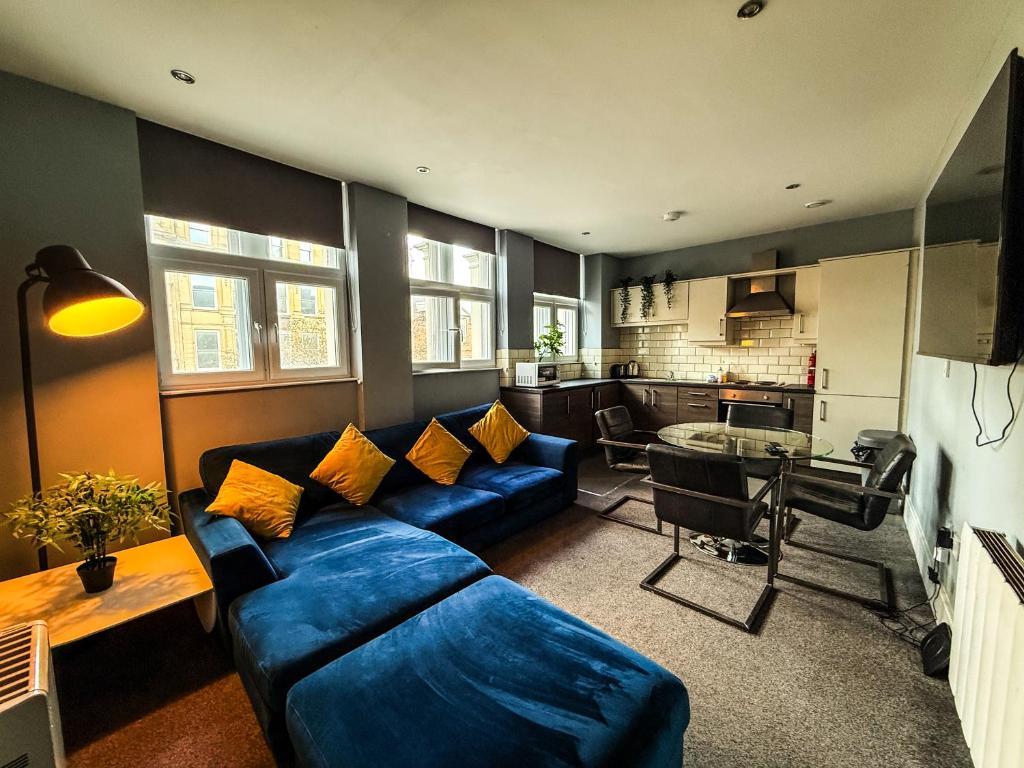 a living room with a blue couch and a table at 3 Bedroom Apartment in the Heart of Newcastle - Modern - Sleeps 6 in Newcastle upon Tyne