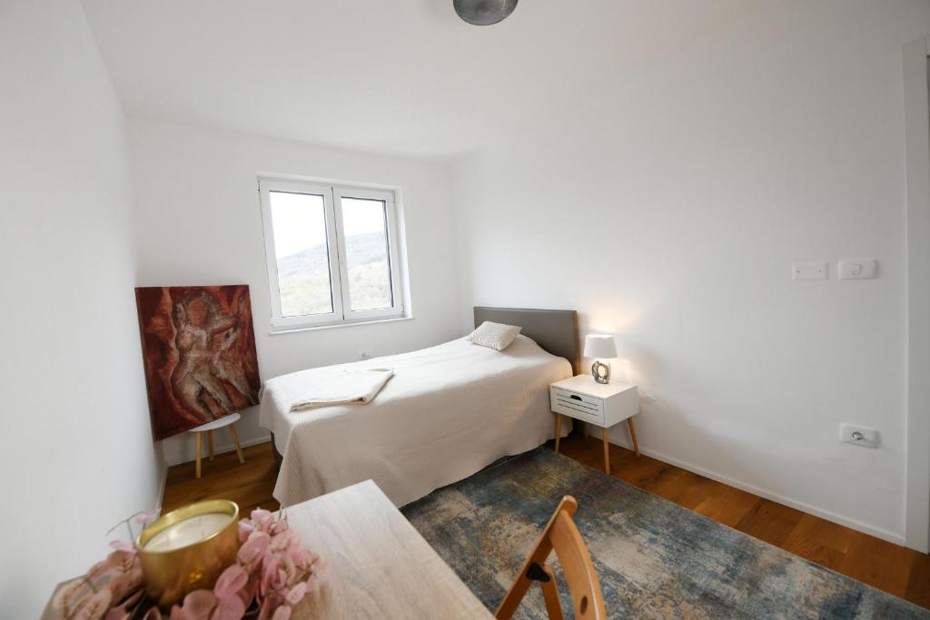 una camera bianca con letto e tavolo di Villa Caprisa a Capodistria