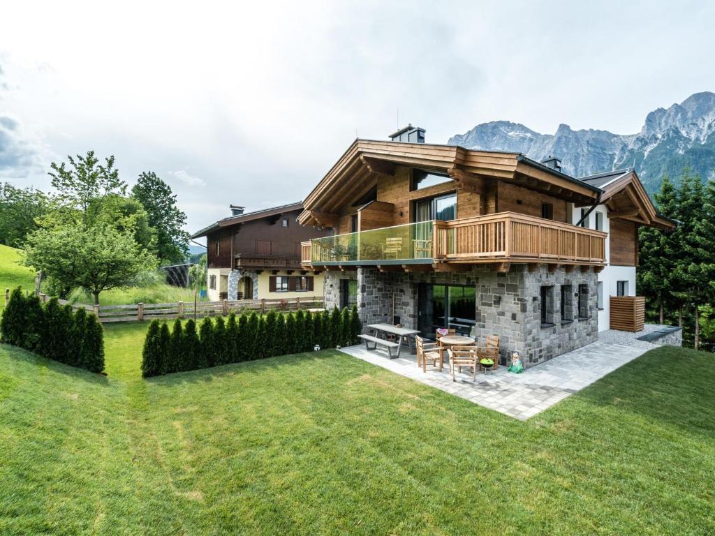 una casa grande con una terraza en el césped en Chalet Schneelöwe S, en Leogang