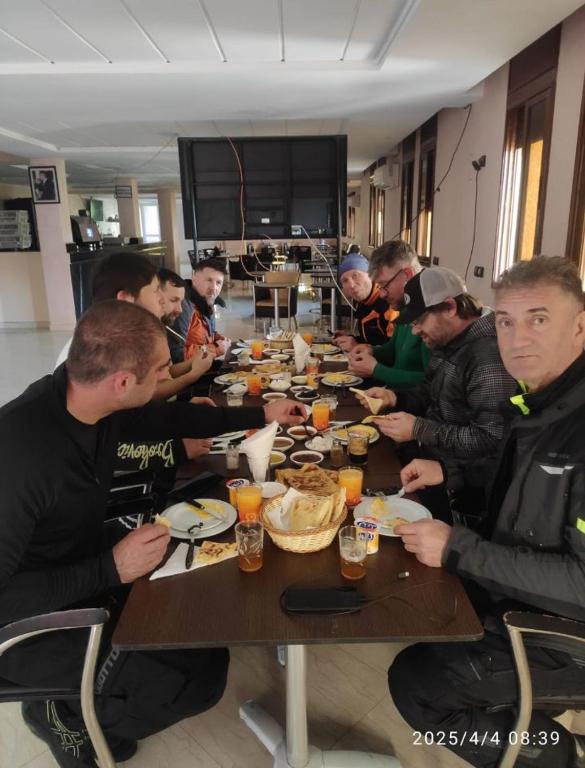 a group of people sitting at a table eating food at Welcome Hôtel Dijon in Ouzoud