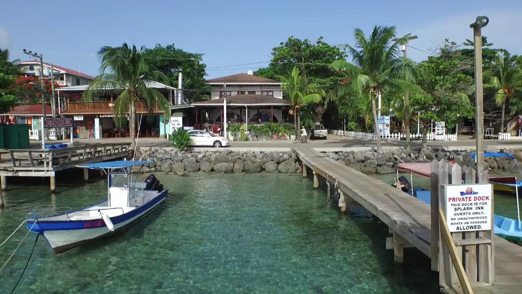 a boat is docked at a dock in the water at Splash Inn Dive Resort & Villas in West End