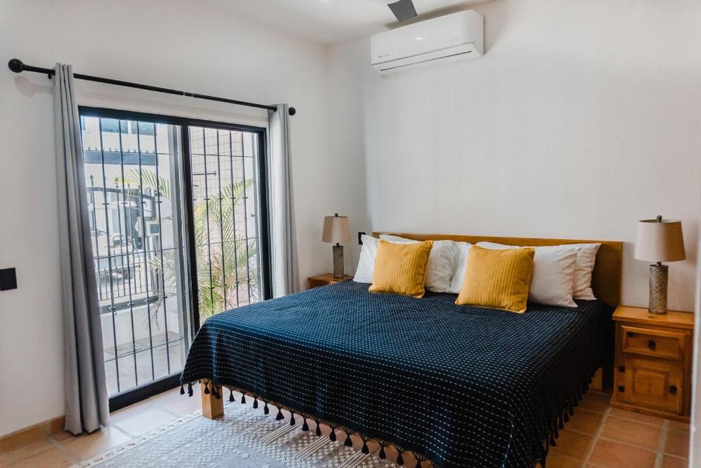 a bedroom with a bed and a large window at Casa Ola Mita in Punta Mita