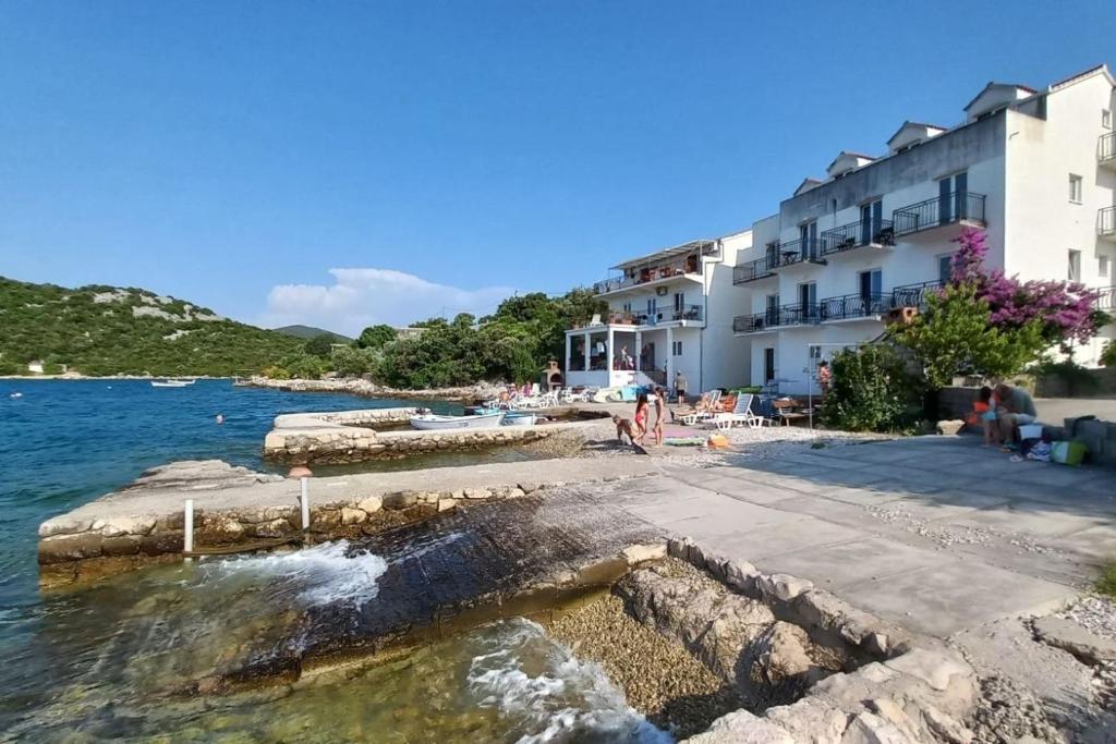 a view of a hotel and the water at Apartments by the sea Cove Pjestata, Peljesac - 24021 in Janjina