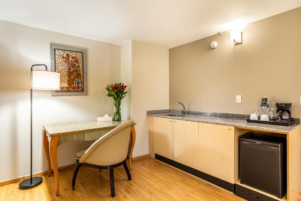 A kitchenette with a sink, under-counter refrigerator and two-chair table.