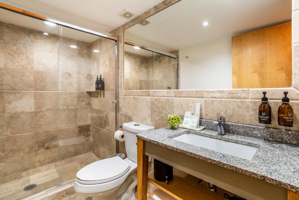 A marble-look bathroom has a glass-enclosed walk-in shower and broad vanity.