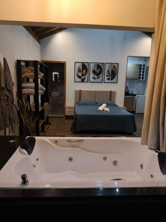 a large bath tub in a room with a bed at Chalé Vista da Serra in Cunha