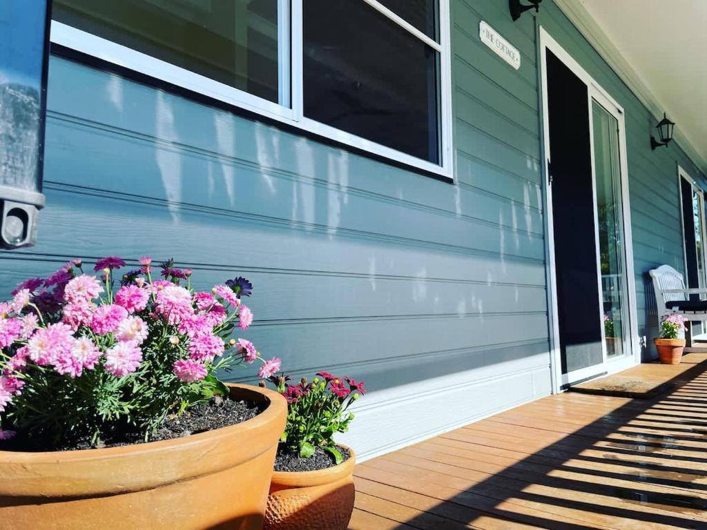 una casa con flores en el porche delantero en Kyogle Farmstay - Charming Country Cottage, en Homeleigh