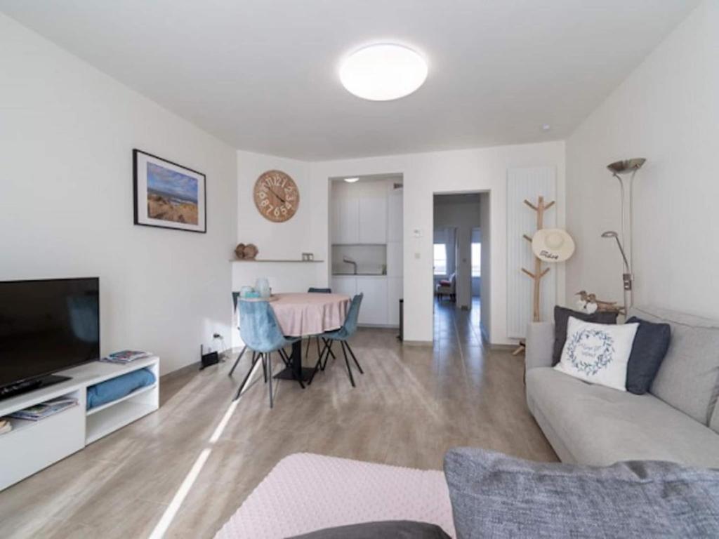 a living room with a couch and a table at Apartment by North Sea with Stunning Views in Middelkerke