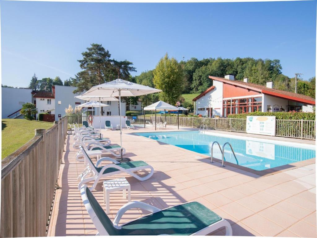 une rangée de chaises longues à côté d'une piscine dans l'établissement Apartment in Saint-Jean-Pied-de-Port with Balcony, à Saint-Jean-Pied-de-Port