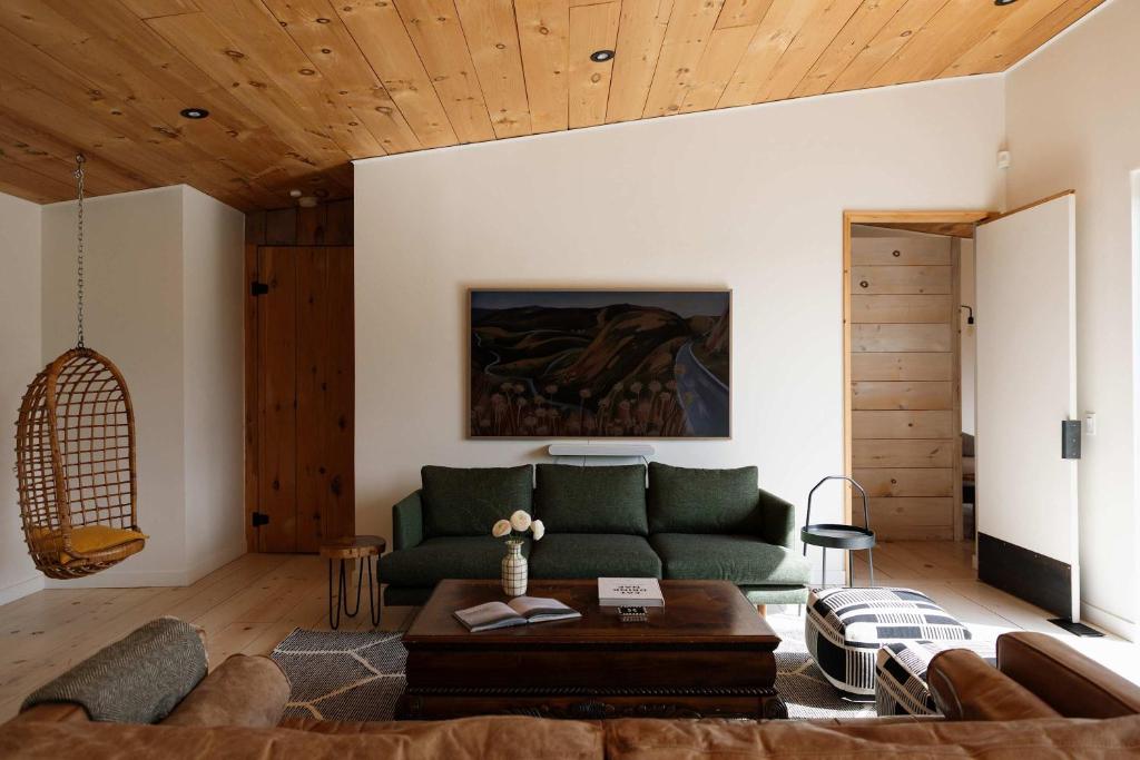 a living room with a green couch and a table at Willow Creek - Modern Sunlit Bungalow in Hillier