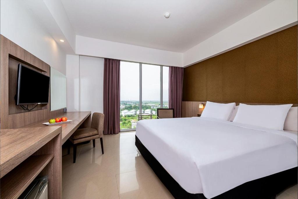 Postel nebo postele na pokoji v ubytování Grand Tan Banjarmasin Hotel & Convention Center
