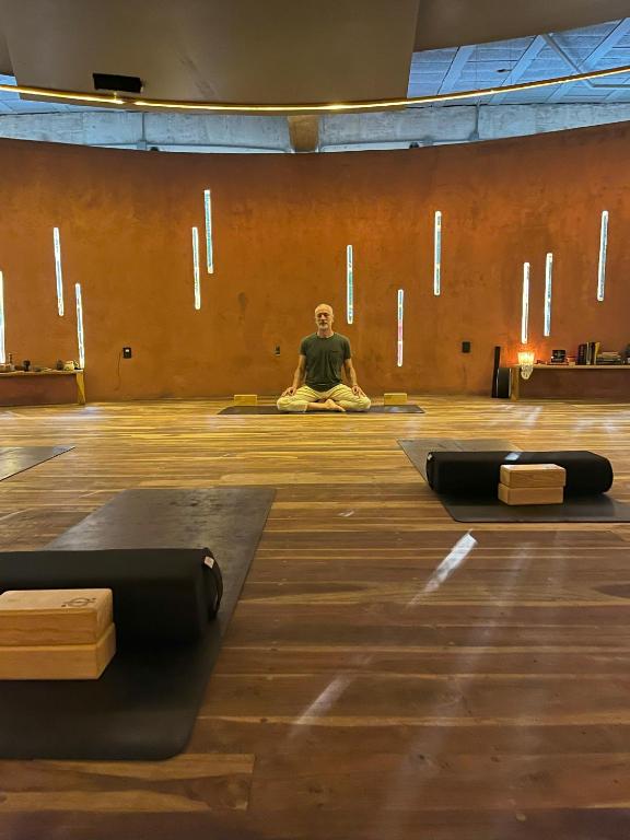 a man sitting on the floor in a room with yoga mats at Calea Tulum Boutique Hotel in Tulum