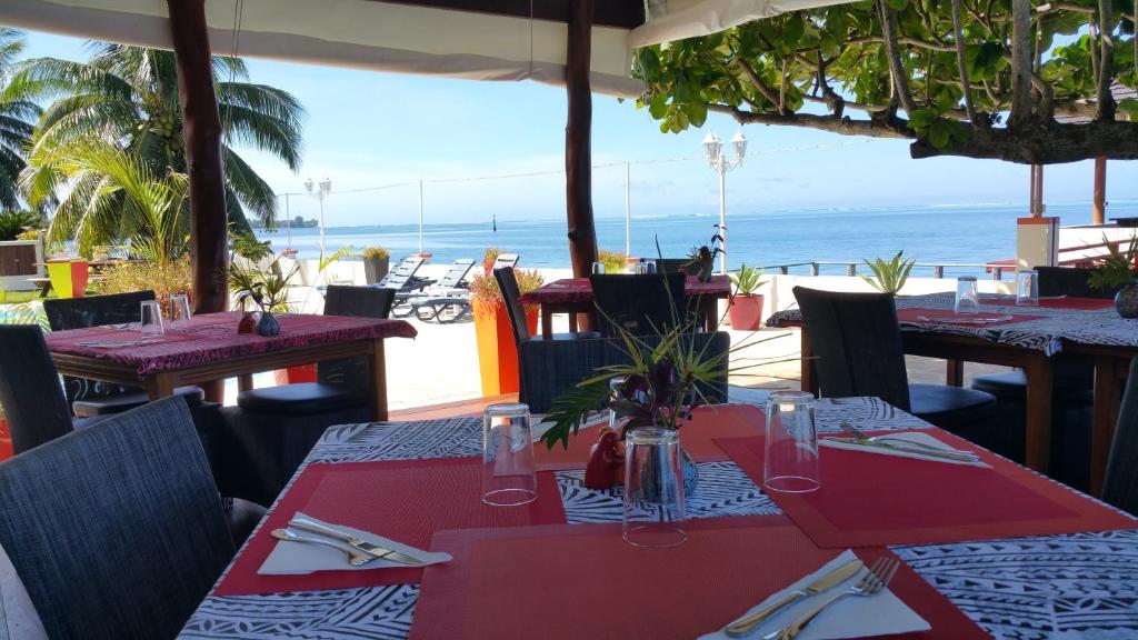 a restaurant with tables and chairs with a view of the ocean at Pension de famille HITI MOANA VILLA in Papara